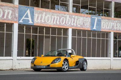 une voiture de sport jaune garée devant un immeuble