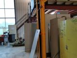 a yellow refrigerator sitting in a room with a staircase in the background