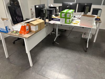 un bureau sur lequel se trouvent un écran d'ordinateur et des cartons