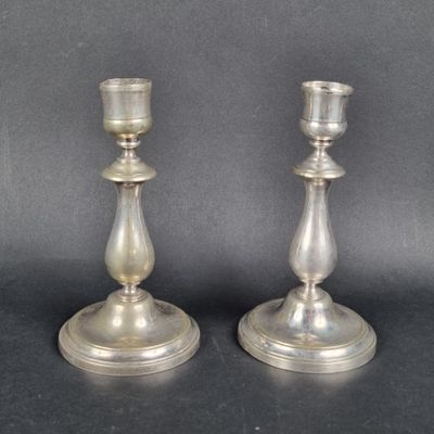 pair of silver candlesticks on a black background