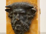 an image of a statue of a man with a beard and a goat ' s head on a marble block