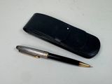 un stylo et un étui en cuir posés sur une table