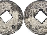 a silver coin with a hole in the middle of it