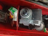 a red box with a camera and other items in it