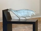 a sculpture of a bird sitting on top of a bench