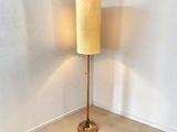 une lampe posée sur un pied en bois dans une pièce