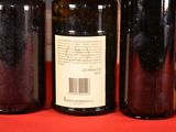 several bottles of wine are lined up on a red table
