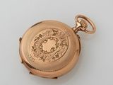 an antique gold pocket watch on a white surface
