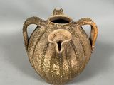 a brown vase with a handle on a white surface