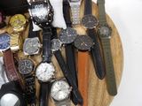 a lot of watches that are sitting on a wooden tray