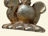 a silver figurine of a bird on a white background