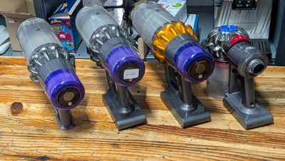 several vacuums are lined up on a wooden table