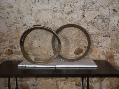 two rings sitting on a table in front of a brick wall