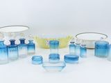de nombreux objets en verre bleu posés sur une surface blanche