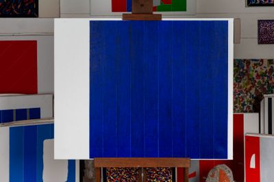 an easel with a blue and white painting on it