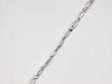 a close up of a silver bracelet on a white surface