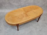 an oval coffee table with a wooden top on a grey background