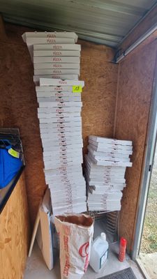 boxes of pizza stacked on top of each other in a storage area