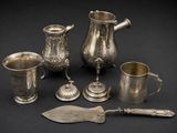 several silverware items are arranged on a black surface