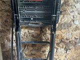 un caddie noir posé à côté d'un mur en pierre