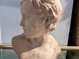 buste en marbre représentant un jeune homme, exposé dans une vitrine