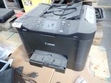 a canon printer sitting on top of a cardboard box
