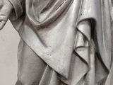 a statue of a man holding a cross in his hands