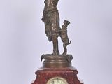une statue en bronze représentant un homme tenant une horloge