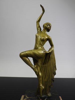 a bronze statue of a female dancer on a marble base