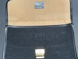 an image of a black purse with a gold clasp on it