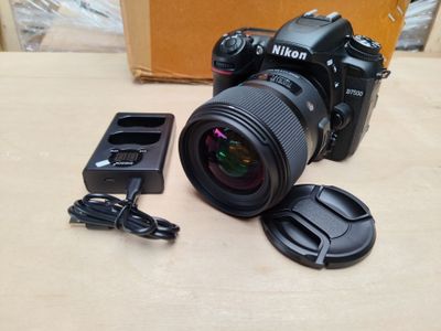 a camera with a lens and a charger on the table