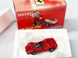 une petite voiture rouge dans une boîte blanche posée sur une table