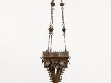 a large brass hanging light fixture with a cross on it