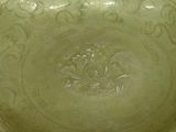 a green bowl sitting on a table with a white table cloth