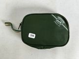 a green bag with a tag on it sitting on a table