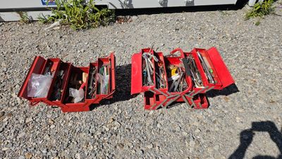 a red tool box with tools in it on the ground