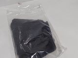 a black shirt in a plastic bag on a white table