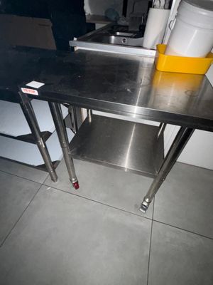 une table en acier inoxydable sur laquelle se trouve une tasse jaune