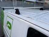 a white van parked in a parking lot with a green sign on the side of the van