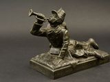 bronze statue of a man playing a trumpet on top of a table