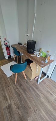 a desk and chair in a room with wood flooring