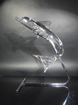 sculpture made of clear glass with a curved base on a black surface