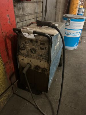 an image of a welding machine in a garage with a red wall