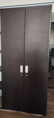 Une armoire haute en mélaminé foncé à deux portes, clés incl…