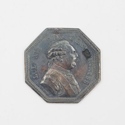 une pièce d'argent sur laquelle figure l'image d'un homme