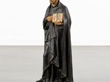 a statue of a man holding a book in his hands