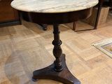 a marble top table with a wooden base on a hard wood floor