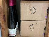 des bouteilles de vin sur une étagère dans un magasin, avec leurs étiquettes de prix