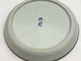 a white plate with blue writing on it sitting on a table