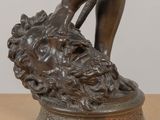 a bronze statue of a woman holding a flower